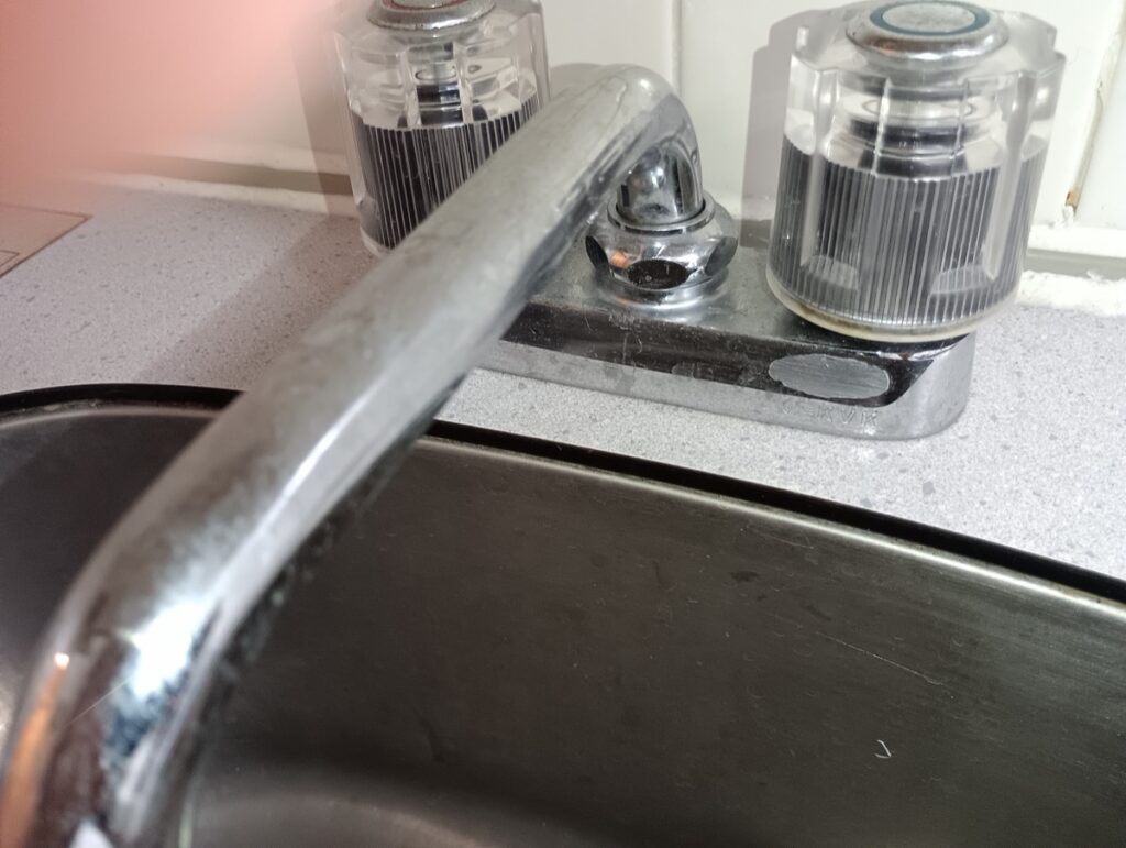 清掃前の混合水栓。吐水口に白い水アカの筋